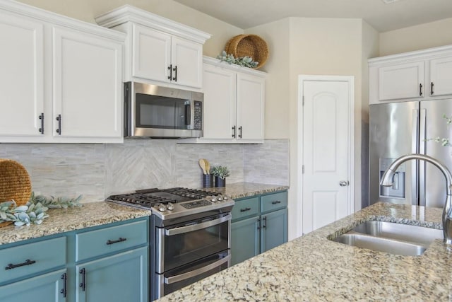 kitchen featuring blue cabinetry, stainless steel appliances, sink, and white cabinets