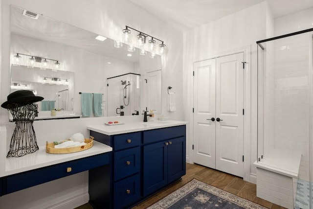 bathroom with wood-type flooring, an enclosed shower, and vanity