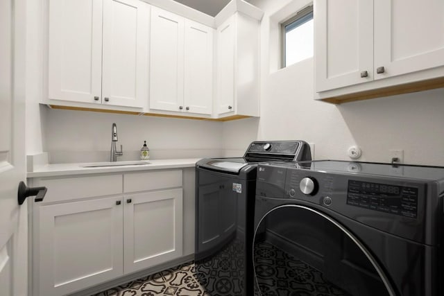 laundry area with cabinets, washing machine and dryer, and sink