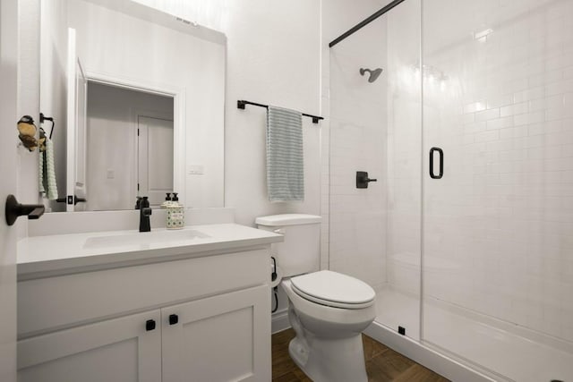 bathroom with walk in shower, vanity, toilet, and wood-type flooring