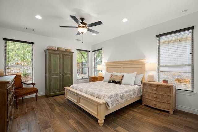 bedroom with multiple windows, dark wood-type flooring, and ceiling fan