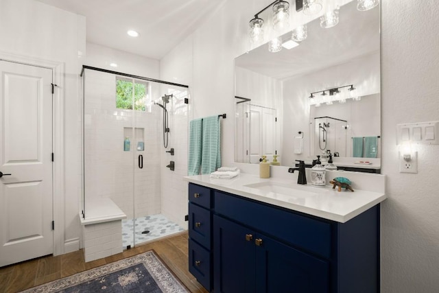 bathroom with vanity, wood-type flooring, and a shower with door