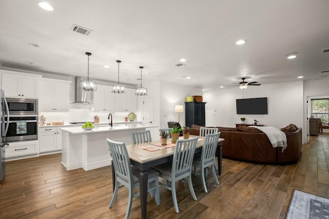 dining area with sink, dark hardwood / wood-style floors, and ceiling fan