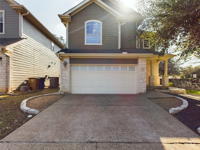 front facade with a garage and central AC unit