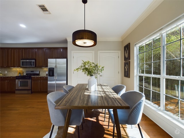 dining room featuring dark hardwood / wood-style flooring and crown molding