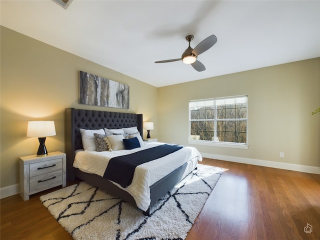 bedroom with dark hardwood / wood-style flooring and ceiling fan