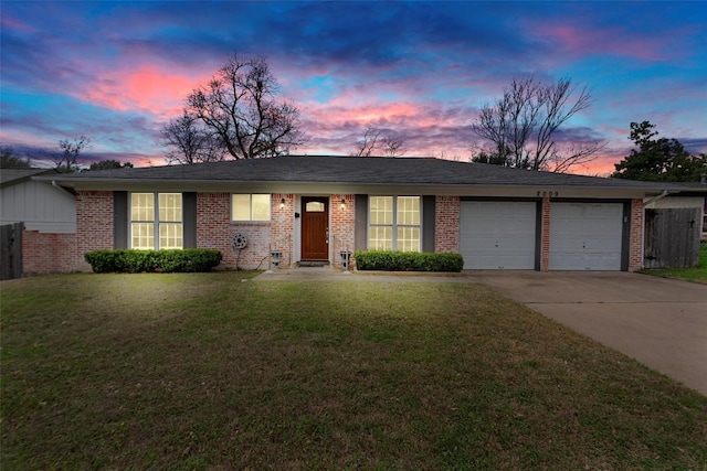 single story home featuring a garage and a yard