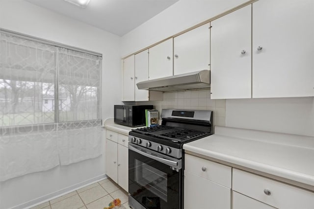 kitchen with stainless steel gas stove, backsplash, white cabinets, and light tile patterned flooring