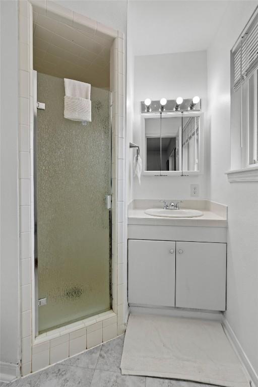 bathroom with vanity and a shower with shower door