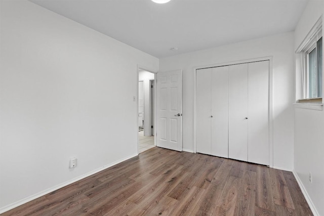 unfurnished bedroom featuring wood-type flooring and a closet