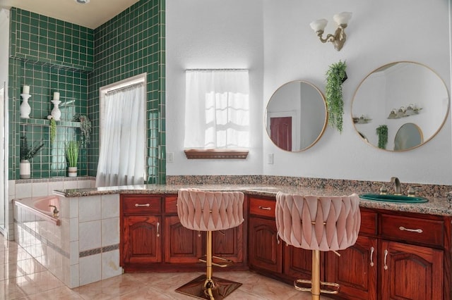 bathroom featuring vanity, tile patterned flooring, and tiled bath