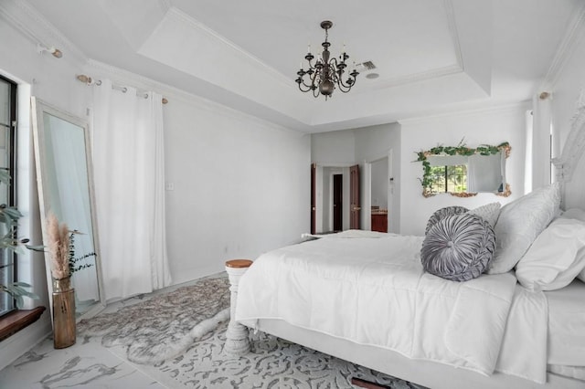 bedroom featuring ornamental molding, connected bathroom, a raised ceiling, and a notable chandelier