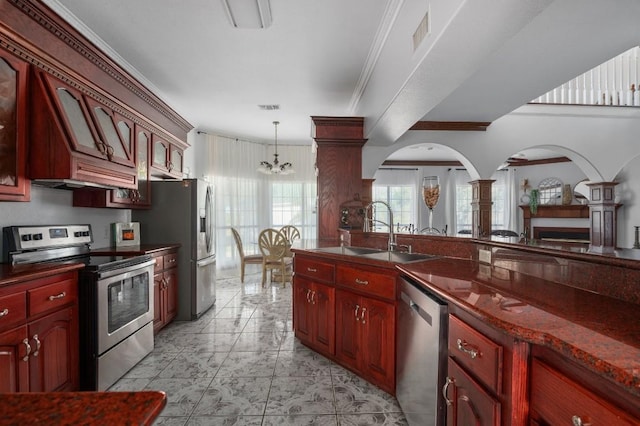 kitchen featuring pendant lighting, sink, an inviting chandelier, stainless steel appliances, and ornamental molding