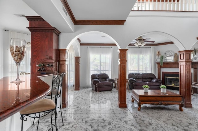 living room with ornamental molding and ceiling fan