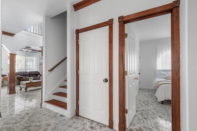 staircase featuring ornate columns and crown molding