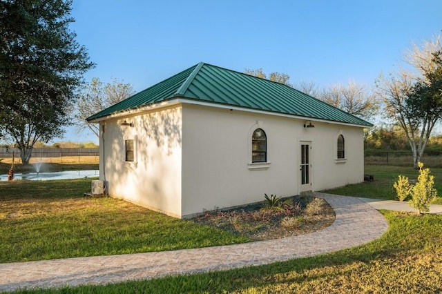 view of side of property with a water view and a lawn