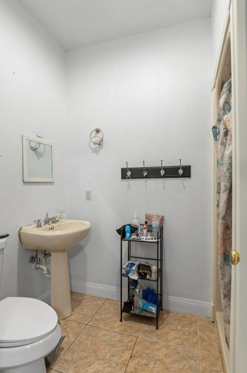 bathroom with tile patterned flooring, sink, a shower with curtain, and toilet