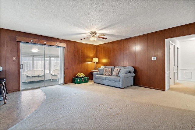 carpeted living room with ceiling fan and a textured ceiling