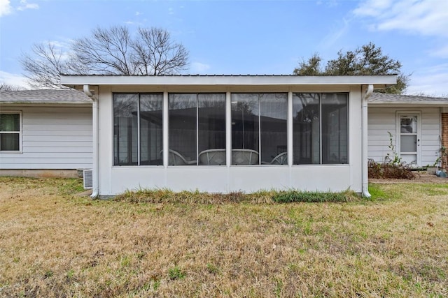 view of side of property featuring a sunroom and a lawn