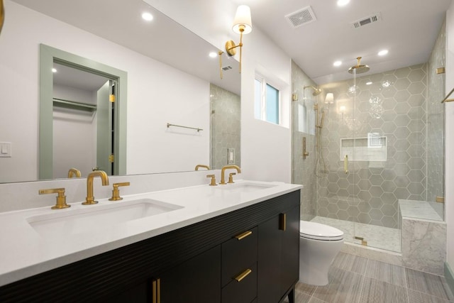 bathroom featuring vanity, tile patterned flooring, a shower with shower door, and toilet