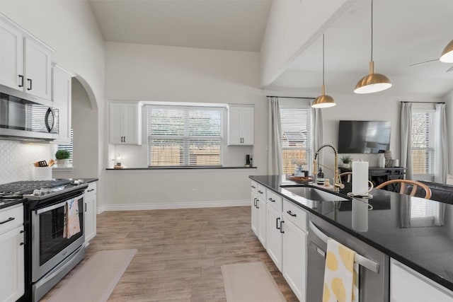 kitchen featuring stainless steel appliances, hanging light fixtures, sink, and white cabinets