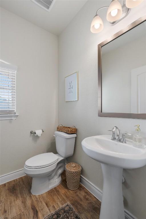 bathroom featuring hardwood / wood-style flooring and toilet