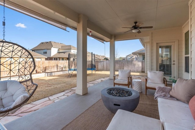 view of patio with a trampoline and a fire pit