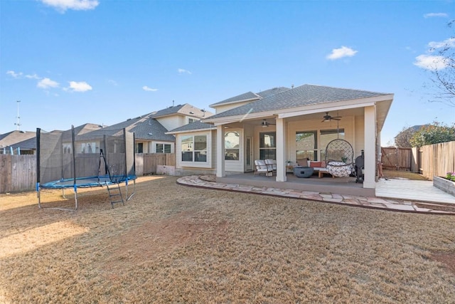 back of house featuring outdoor lounge area, a trampoline, ceiling fan, and a patio area