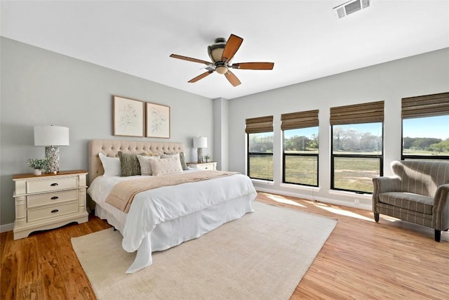 bedroom featuring multiple windows, light wood-type flooring, visible vents, and a ceiling fan