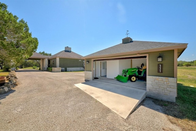 view of front of home featuring a garage, roof with shingles, and driveway