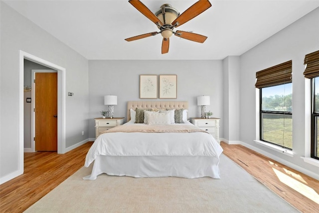 bedroom with a ceiling fan, baseboards, and wood finished floors