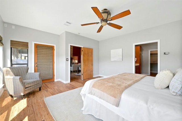 bedroom with a closet, visible vents, ceiling fan, wood finished floors, and baseboards