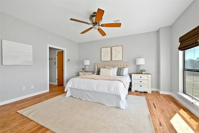 bedroom with ceiling fan, baseboards, and wood finished floors