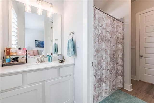 bathroom featuring wood-type flooring, curtained shower, and vanity