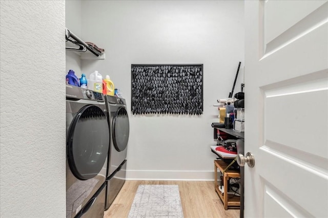 clothes washing area with light hardwood / wood-style floors and independent washer and dryer