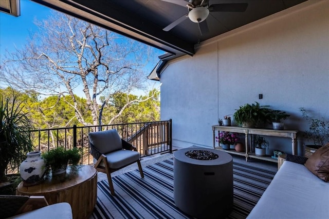 balcony featuring ceiling fan and a fire pit