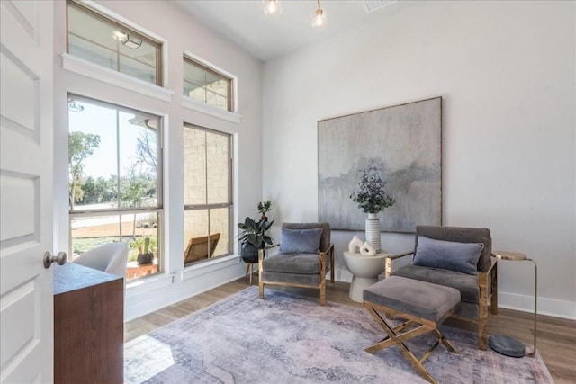 sitting room with hardwood / wood-style floors and a high ceiling