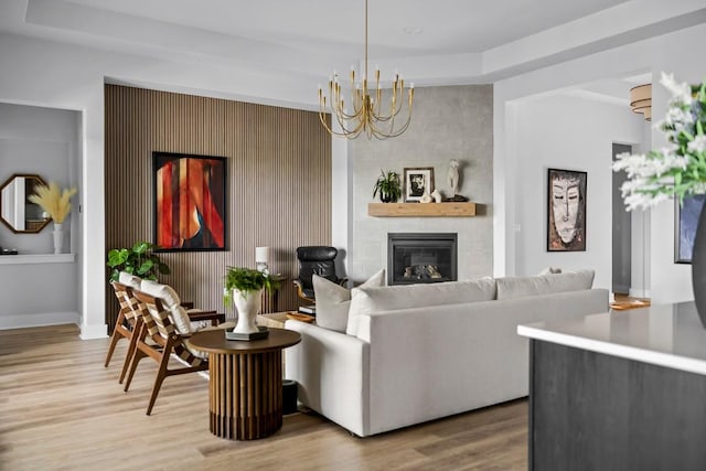 living room with a large fireplace, a chandelier, and hardwood / wood-style floors