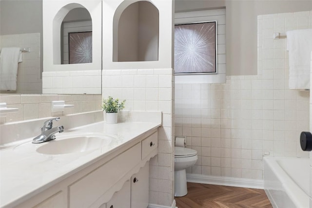 bathroom with tile walls, vanity, parquet floors, a tub, and toilet