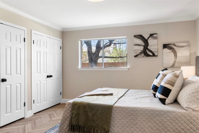 bedroom featuring multiple closets, ornamental molding, and light parquet flooring