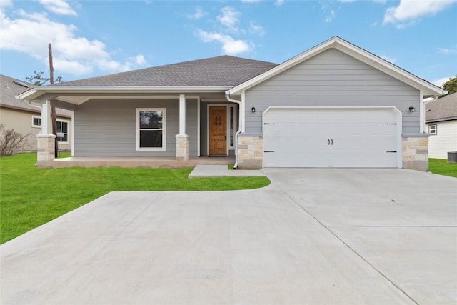 view of front facade featuring a porch, a garage, and a front lawn