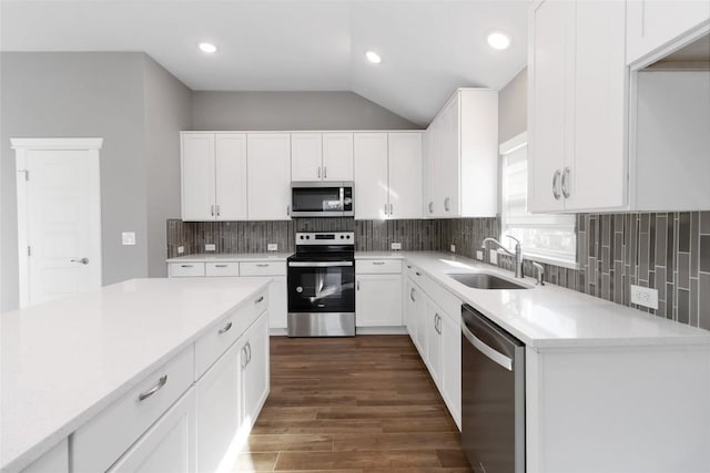 kitchen featuring tasteful backsplash, white cabinetry, sink, dark hardwood / wood-style flooring, and stainless steel appliances