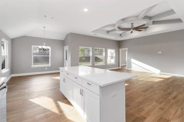 kitchen featuring light hardwood / wood-style flooring, ceiling fan with notable chandelier, white cabinetry, a center island, and decorative light fixtures