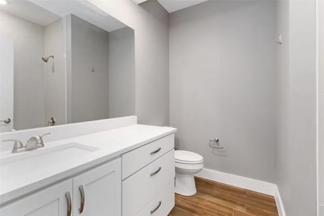 bathroom featuring vanity, toilet, and walk in shower