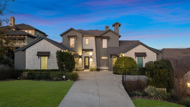 905 Madison Fork Dr, Lakeway, TX 78738 - view of front of house with stone siding, a front lawn, concrete driveway, a chimney, and roof with shingles