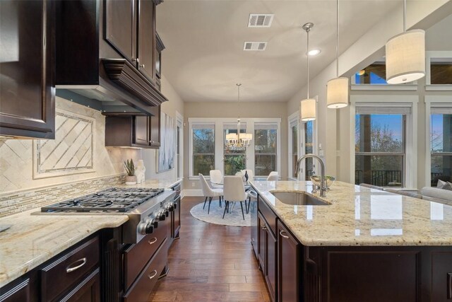 905 Madison Fork Dr, Lakeway, TX 78738 - kitchen with dark wood finished floors, a chandelier, tasteful backsplash, light stone counters, and recessed lighting