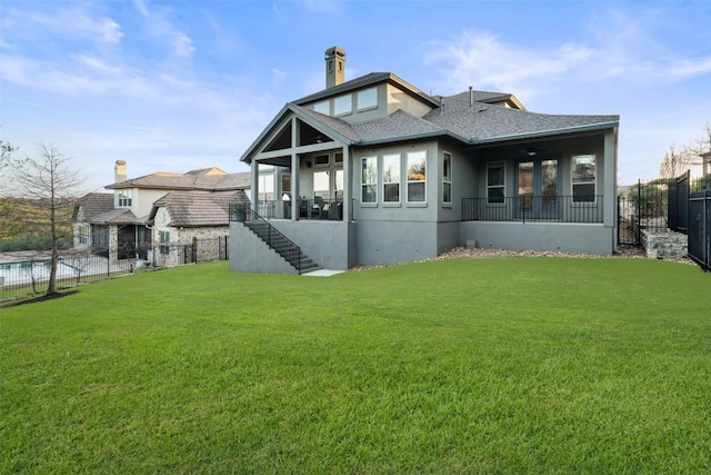 rear view of property featuring a yard and ceiling fan