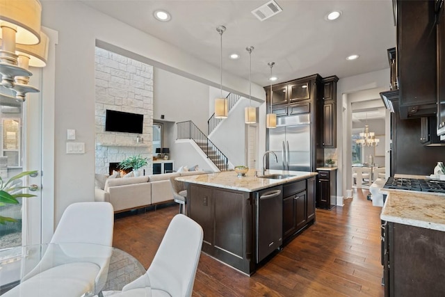 905 Madison Fork Dr, Lakeway, TX 78738 - kitchen with a chandelier, stainless steel appliances, open floor plan, dark brown cabinetry, and recessed lighting