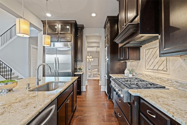 905 Madison Fork Dr, Lakeway, TX 78738 - kitchen featuring appliances with stainless steel finishes, dark brown cabinetry, tasteful backsplash, light stone countertops, and recessed lighting