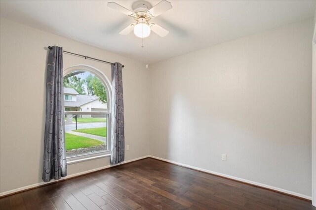 spare room with dark wood-type flooring and ceiling fan